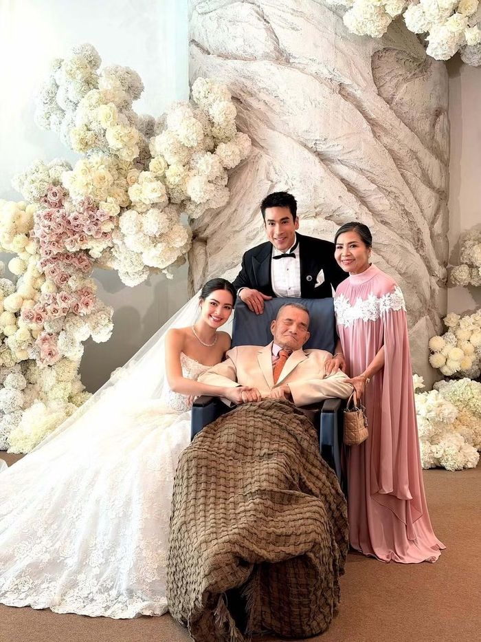 Cặp vợ chồng chụp ảnh cùng ông Yoshio Kugimiya (82 tuổi, bố của Nadech). Trong ngày cưới, Yaya chọn váy ren trắng cúp ngực, kết hợp khăn voan dài, còn Nadech lịch lãm với tuxedo đen và nơ cổ đồng màu.