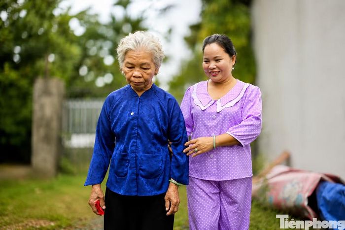 Chị Nguyễn Thanh Thủy (con gái nuôi) xúc động khi bà Nguyễn Thị Lệ chính thức được công nhận là vợ liệt sĩ Huỳnh Văn Quên sau 58 năm chờ đợi. Ảnh: Nguyễn Tiến