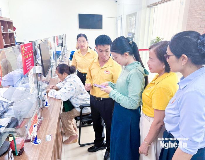 Cán bộ Mặt trận xã Anh Sơn hướng dẫn người dân thực hiện phản ánh, đóng góp ý kiến qua online về thực hiện thủ tục hành chính và chuyển đổi số tại Trung tâm Phục vụ hành chính công xã Anh Sơn. Ảnh: Mai Hoa