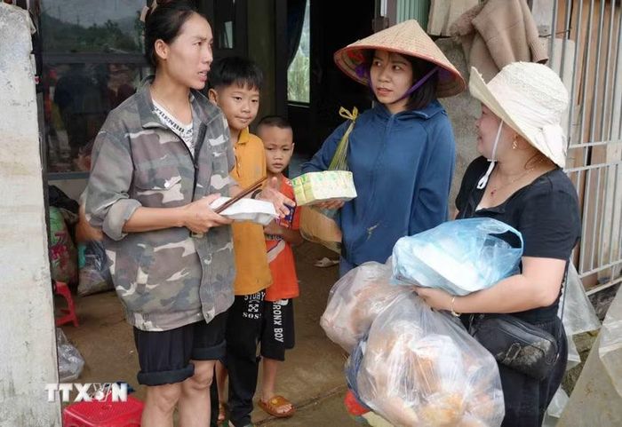 Tiếp tế thực phẩm cho những gia đình bị lũ cuốn trôi. (Ảnh: Nguyễn Oanh/TTXVN)