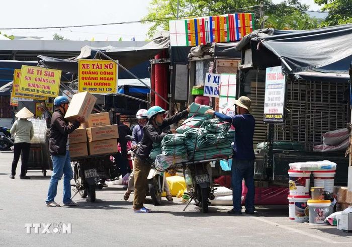 Nhọc nhằn sắp xếp hàng hóa giữa nắng nóng gay gắt ở Bến xe Đông Ba, phường Phú Xuân, thành phố Huế. (Ảnh: Nguyên Lý/TTXVN)