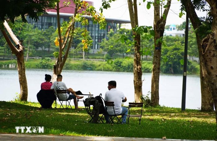 Người dân đến công viên bờ Bắc sông Hương, thành phố Huế để hóng mát, tránh nắng nóng gay gắt. (Ảnh: Nguyên Lý/TTXVN)