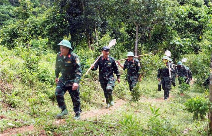 Nhiều khu vực tìm kiếm nằm sâu trong rừng, Đội Quy tập hài cốt liệt sĩ thuộc Đoàn Kinh tế - Quốc phòng 337, Quân khu 4, phải kết hợp đi xe máy và đi bộ nhiều giờ. Ảnh: Tá Chuyên/TTXVN