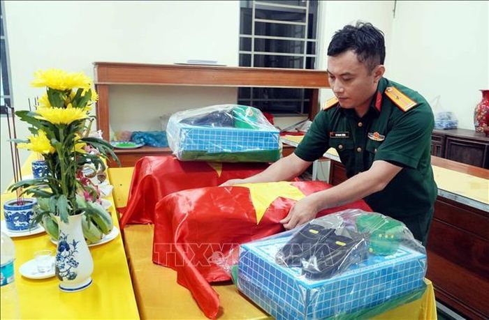 Thiếu tá Dư Quang Vượng túc trực, lo hương khói cho các Liệt sĩ tại Nghĩa trang Liệt sĩ Khe Sanh (Quảng Trị) sau khi quy tập. Ảnh: Tá Chuyên/TTXVN