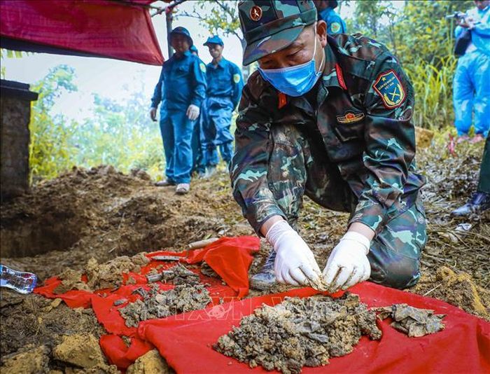 Trung tá Đào Xuân Trường, Trợ lý Chính sách Phòng chính trị Bộ CHQS tỉnh Điện Biên nhẹ nhàng làm sạch từng phần hài cốt và di vật vừa được phát hiện.