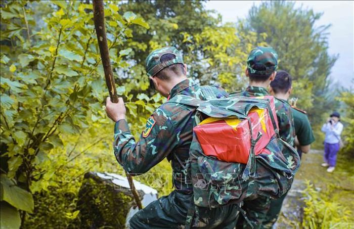 Một chiến sĩ cõng hài cốt liệt sĩ vượt quãng đường dốc, trơn trượt trên đỉnh đèo Pha Đin để đưa các anh trở về với đồng đội.