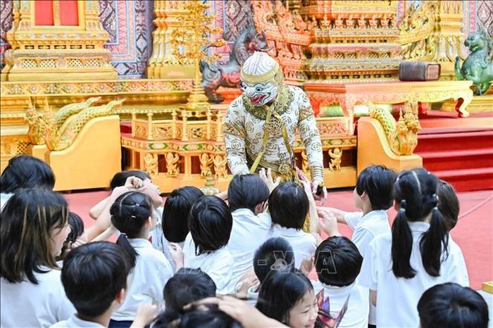 Nghệ sĩ kịch múa mặt nạ Khon giao lưu cùng các học sinh trong một buổi biểu diễn. Ảnh: Phạm Hải/TTXVN