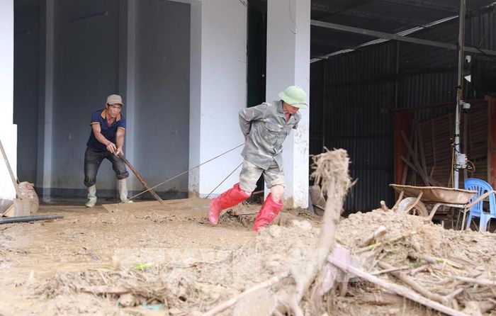 Người dân xã Mường Than, tỉnh Lai Châu tập trung dọn dẹp bùn đất sau khi cơn lũ đi qua. Ảnh: Quý Trung - TTXVN