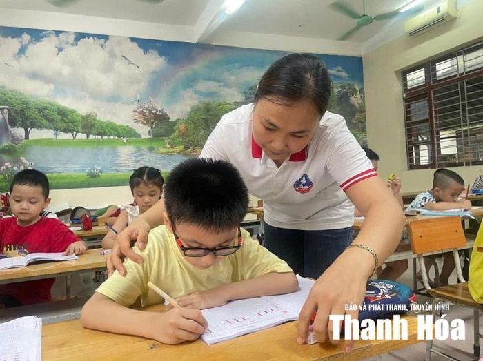 Giáo viên hướng dẫn học sinh làm quen với chữ cái.