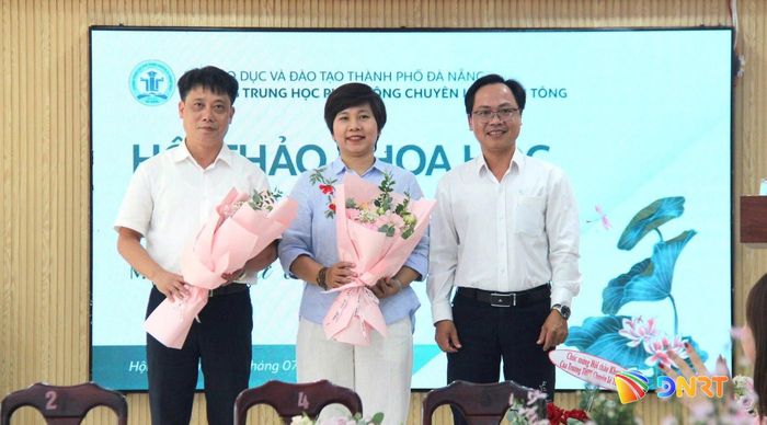 Thầy Lê Thành Vinh, Hiệu trưởng nhà trường (bên phải) tặng hoa chuyên gia Bộ Giáo dục và Đào tạo và chuyên viên Sở Giáo dục và Đào tạo thành phố Đà Nẵng tại hội thảo khoa học. Ảnh: TRÂM NGỌC