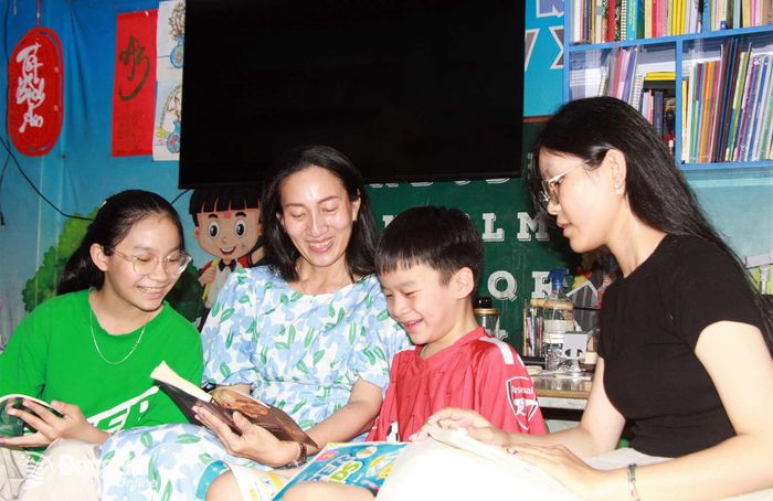 Bốn mẹ con bà Nguyễn Thị Phương Anh cùng đọc sách, trò chuyện vui vẻ sau những giờ đi làm, đi học. Ảnh: Nga Sơn