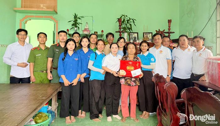 Cán bộ Ủy ban MTTQ Việt Nam xã Phước An cùng thế hệ trẻ tặng quà và giúp lau dọn căn nhà của gia đình bà Hà Thị Được - người đang thờ cúng liệt sĩ Hà Văn Phải. Ảnh: Đoàn Mai