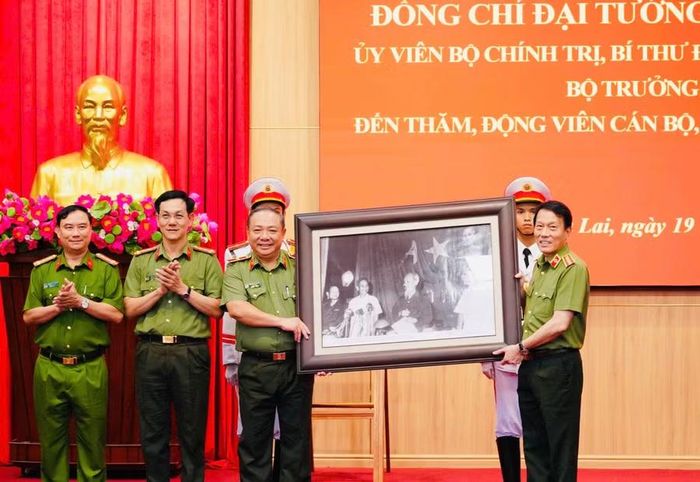 Bộ trưởng Bộ Công an Lương Tam Quang (bên phải) tặng quà lưu niệm cho lãnh đạo Công an tỉnh Gia Lai. Ảnh: N.H