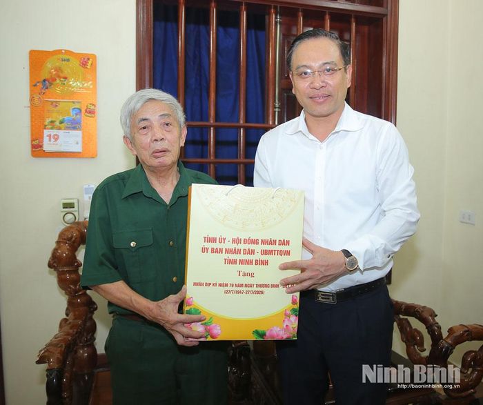 Đồng chí Đặng Thanh Sơn, Phó Chủ tịch UBND tỉnh tặng quà cho ông Phạm Mạnh Hùng - thương binh 81% đặc biệt nặng.