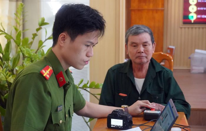 Cán bộ Công an hỗ trợ, hướng dẫn thân nhân liệt sĩ thực hiện quy trình lấy mẫu ADN - Ảnh: N.M