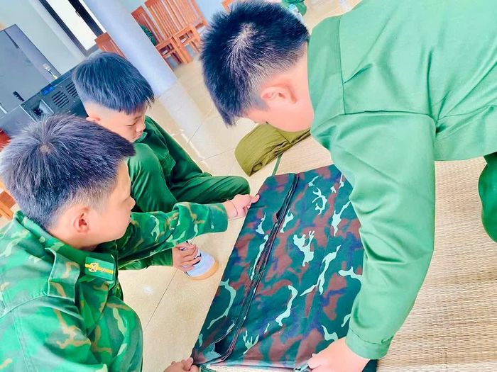 Dưới sự hướng dẫn của cán bộ huấn luyện, các học viên làm quen với nếp sống chính quy, bắt đầu từ việc gấp chăn màn gọn gàng, vuông vức.