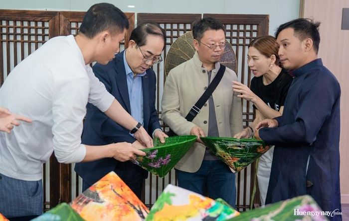 Khách tìm hiểu về nón lá Huế. Ảnh: Sở Du Lịch