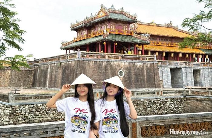 Du khách Hà Nội chụp ảnh lưu niệm trước Đại Nội. Ảnh: Minh Anh