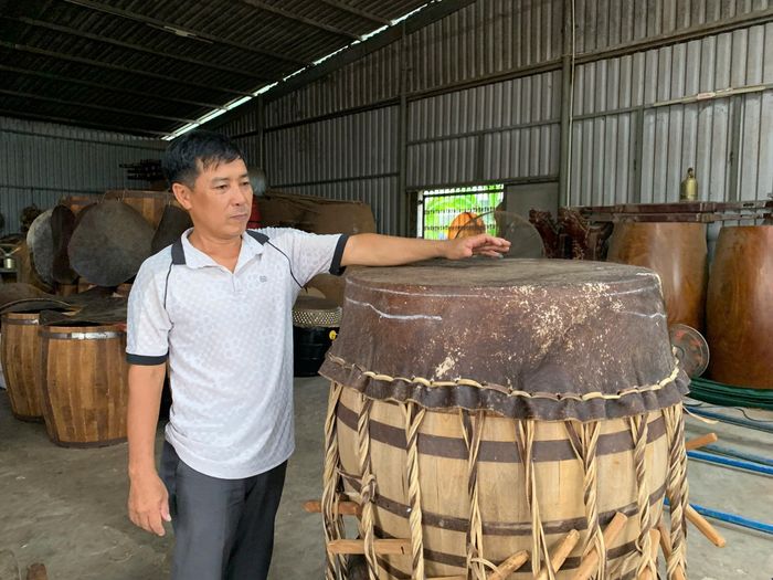 Nghệ nhân Nguyễn Văn An giới thiệu quy trình chế tác và những giá trị truyền thống được gìn giữ qua nhiều thế hệ tại làng trống Bình An. Ảnh: Đông Dương.