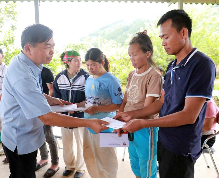 Thứ trưởng Bộ Nông nghiệp và Môi trường - Nguyễn Hoàng Hiệp tặng quà các hộ bị ảnh hưởng nặng nề ở Mường Than do đợt mưa lũ.