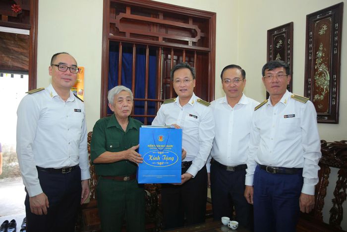 Tổng Kiểm toán nhà nước Nguyễn Hữu Nghĩa tặng quà thương binh Phạm Mạnh Hùng. Ảnh: Diệu Thiện