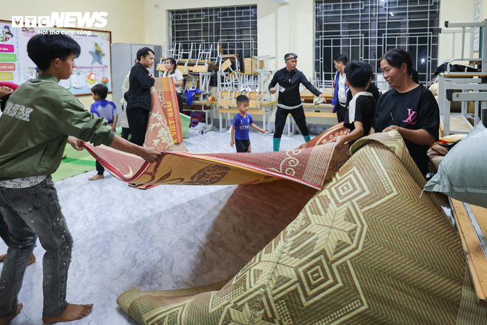 Những phòng học tại điểm trường Pắc Ta nhanh chóng được trưng dụng làm nơi ở tạm. Bàn ghế được kê gọn vào góc lớp, nhường chỗ cho những tấm chiếu, chăn và gối trải kín nền nhà.