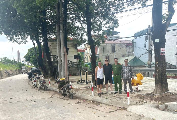 Thiếu tá Ngô Minh Ngọc và người dân phấn khởi sau khi hoàn thành việc dựng hàng rào. Ảnh: Tuệ Lâm