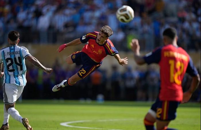 Curbasi (ĐT Tây Ban Nha) văng lên cao sau khi bị Fernandez (ĐT Argentina) phạm lỗi trong trận Chung kết World Cup 2026. Ảnh: Frank Franklin II/ AP Photo.