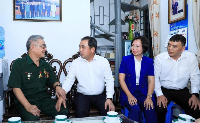 Bí thư Thành ủy Hà Nội Trần Đức Thắng thăm hỏi sức khỏe thương binh Trần Huy Tắn. Ảnh: QT