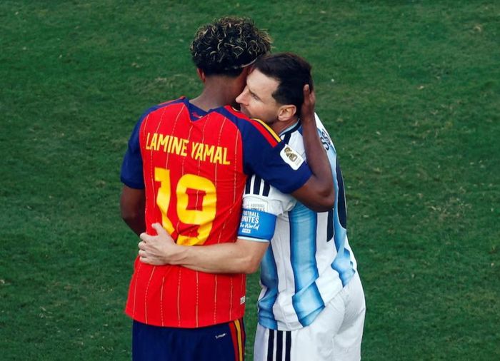 Lamine Yamal ôm Lionel Messi sau trận chung kết World Cup 2026. Khoảnh khắc giữa hai thế hệ cầu thủ nhận được nhiều sự chú ý trên mạng xã hội. Ảnh: Jeenah Moon/Reuters.