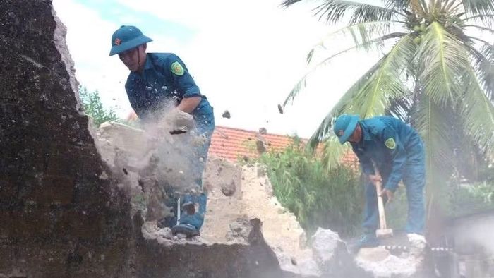 Lực lượng dân quân xã Ninh Châu (Quảng Trị) tham gia hỗ trợ phá dỡ nhà cũ đến xây nhà mới cho gia đình nạn nhân chất độc hóa học. (Ảnh nhandan.vn)