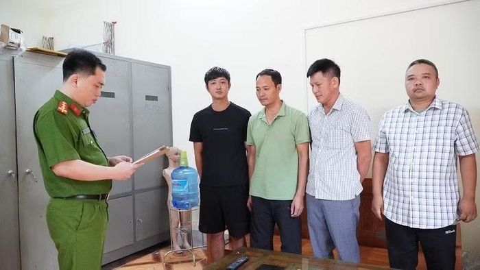 Cán bộ cơ quan điều tra Công an tỉnh Điện Biên đọc quyết định khởi tố bị can đối với 4 đối tượng. (Ảnh: CÔNG AN ĐIỆN BIÊN)