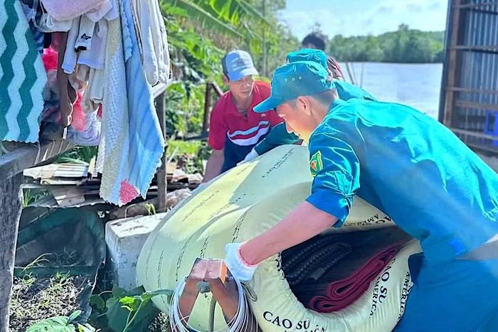 Lực lượng chức năng và đoàn thể xã Đất Mới (tỉnh Cà Mau) hỗ trợ giúp dân khắc phục hậu quả sau sạt lở đất.