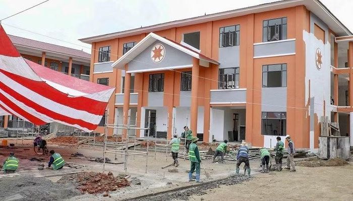 Công nhân Công ty Thương mại-Xây dựng số 6 đang thi công lát gạch sân, đường trên khuôn viên Trường nội trú liên cấp Thanh Nưa.