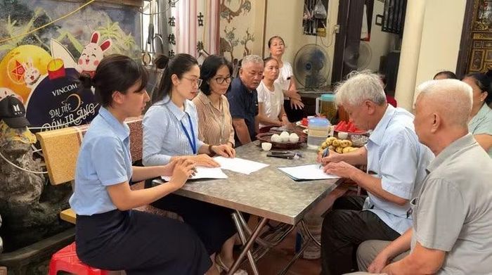 Các cán bộ Điểm hỗ trợ dịch vụ công số Kiến Hưng hỗ trợ người cao tuổi tại nhà. (Ảnh Trung tâm Phục vụ hành chính công Hà Nội)