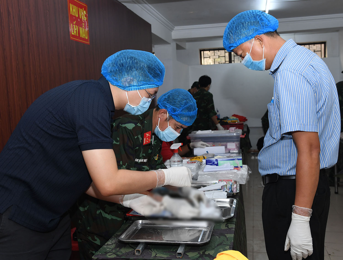 Thực hiện lấy mẫu hài cốt liệt sĩ.