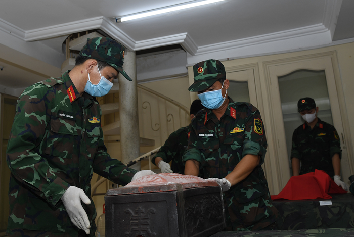 Cán bộ, chiến sĩ đưa hài cốt liệt sĩ vào quách.