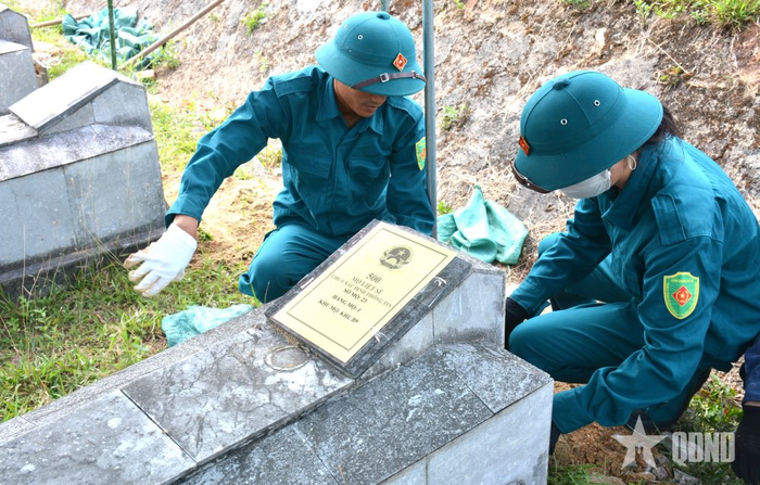 Lực lượng dân quân sửa lại mặt bằng trước lúc hoàn trả lại mộ cho các liệt sĩ.