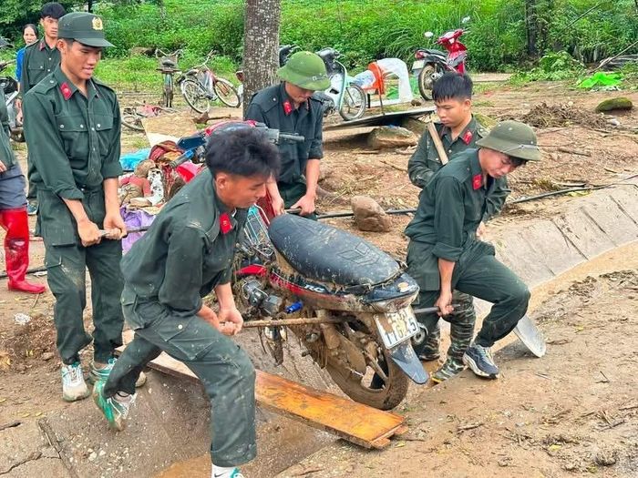 Lực lượng chức năng hỗ trợ người dân xã Mường Than khắc phục thiệt hại do thiên tai gây ra. Ảnh: CÔNG AN TỈNH LAI CHÂU