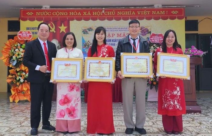 Ông Trần Xuân Chính, Hiệu trưởng Trường Tiểu học Nguyệt Đức trao thưởng cho cán bộ, giáo viên nhà trường.