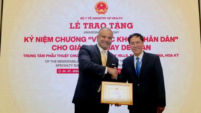 Ông Đặng Quang Tấn – Vụ trưởng Vụ Hợp tác quốc tế, Bộ Y tế (phải) trao Kỷ niệm chương "Vì sức khỏe nhân dân" cho Giáo sư Uday Devgan – chuyên gia quốc tế về phẫu thuật đục thủy tinh thể và khúc xạ (trái).