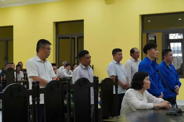 Các bị cáo đứng tại phiên tòa.