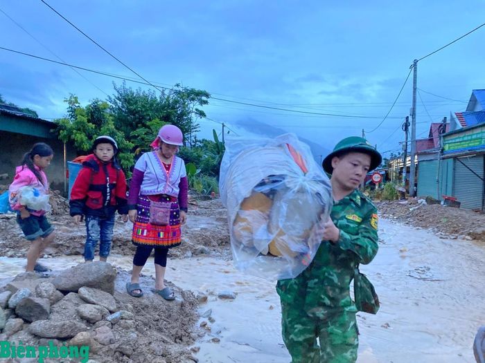 Cán bộ, chiến sĩ Bộ đội Biên phòng tỉnh Lai Châu giúp người dân bản Noon Thăng, xã Mường Than sơ tán khỏi nơi có nguy cơ sạt lở cao. Ảnh: Đức Duẩn