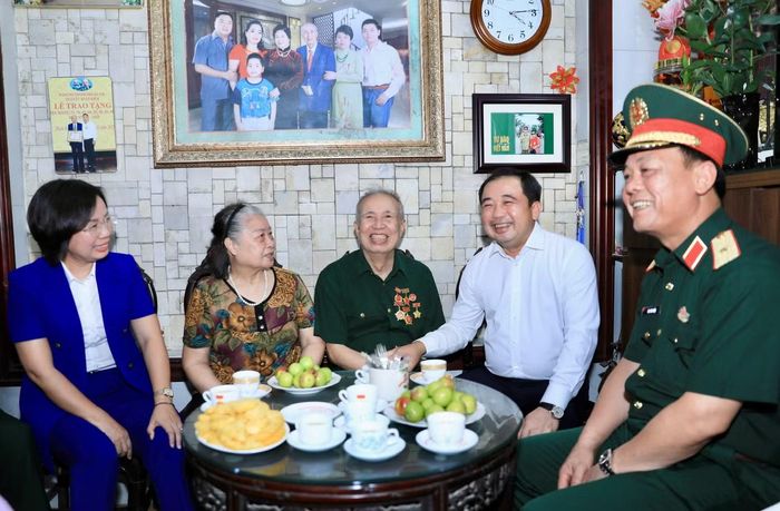 Bí thư Thành ủy Hà Nội Trần Đức Thắng trò chuyện với ông Vũ Đình Hồi (sinh năm 1940), thương binh 3/4 tại địa chỉ số 30 Hàng Vôi, phường Hoàn Kiếm. Ảnh: Q.T.