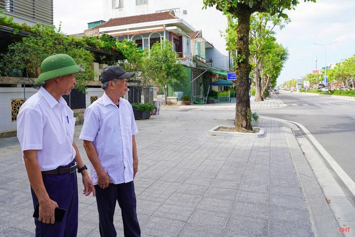  Ông Trần Đình Tân (người đội mũ đen) cùng bà con TDP 30 phấn khởi khi tuyến đường Nguyễn Du khang trang hơn. 