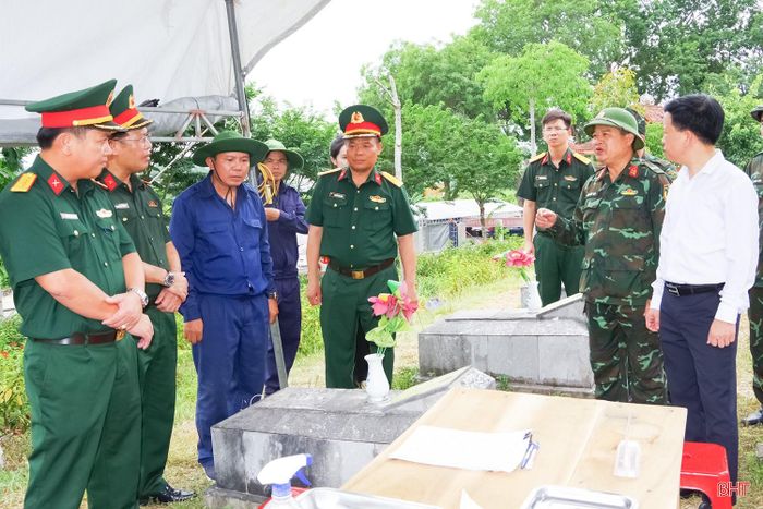 Đại tá Nguyễn Hà - Phó Chủ nhiệm Chính trị Bộ CHQS tỉnh Hà Tĩnh (người thứ 2 bên phải) báo cáo tiến độ thực công việc tại Nghĩa trang Liệt sĩ Nầm (xã Tứ Mỹ). Ảnh: Dương Hoàng.