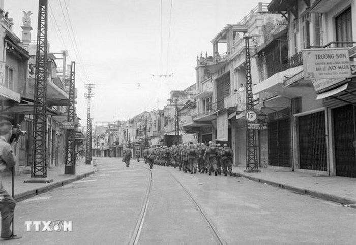 Theo các điều khoản Hiệp định Geneva, quân Pháp có 80 ngày để rút quân khỏi Hà Nội. Ngày 8/10/1954, quân Pháp làm lễ hạ cờ và ngày 9/10 bắt đầu rút khỏi Hà Nội. Quân Pháp rút đến đâu, bộ đội ta tiến vào tiếp quản tới đó. Đúng 16h30 ngày 9/10/1954, quân Pháp rút hết qua cầu Long Biên, quân ta hoàn toàn kiểm soát thành phố. Trong ảnh: Lực lượng bộ binh Pháp lặng lẽ rút qua phố Hàng Đào lên cầu Long Biên (Hà Nội) để xuống Hải Phòng, chiều 9/10/1954. (Ảnh: Tư liệu TTXVN)