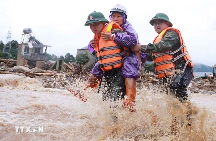 Lực lượng Công an cùng Quân đội đưa người dân ra khỏi nơi nguy hiểm tại khu vực xảy ra lũ quét xã Mường Than, tỉnh Lai Châu. (Ảnh: Quý Trung/TTXVN)