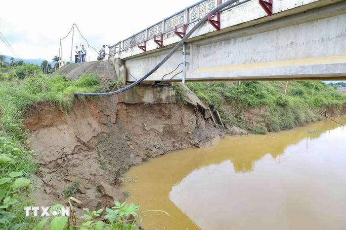 Dòng chảy tiếp tục khoét sâu vào bờ sông, mở rộng phạm vi sạt lở khu vực chân cầu. (Ảnh: Xuân Tư/TTXVN)
