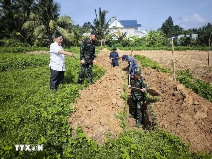 Ông Lê Văn Huệ (trái), xã Tân Thành Bình, tỉnh Vĩnh Long, cung cấp thông tin cho lực lượng tìm kiếm hài cốt liệt sỹ tại Nghĩa trang liệt sỹ tạm ấp Tân Hòa. (Ảnh: Huỳnh Phúc Hậu/TTXVN)